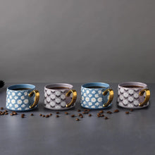 Stoneware teacup mugs set of 4 arranged in a row, gold handles, daisy and circle prints