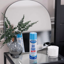 Sprayway glass cleaner aerosol can with blue cap standing near a mirror