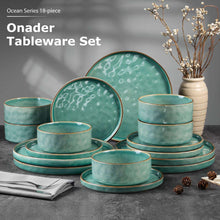 Green speckled stoneware dinnerware set with stacked plates and bowls.