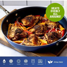 Blue nonstick skillet filled with browned meatballs and vegetables