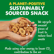 Hand holding crunchy banana bites snack with planet-positive message on bag
