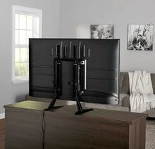 Tabletop TV stand with black metal legs holding a flat-screen TV