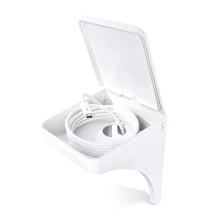 White wall outlet shelf showing cord loop in storage compartment with raised cover