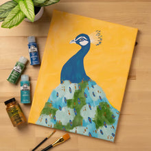 Canvas painting with peacock design, acrylic paint bottles and paintbrush on tabletop