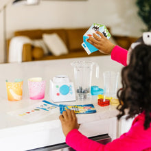 Wooden smoothie maker set on table with blender, cups, and toy ingredients