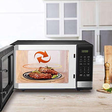 Microwave oven door open showing plate food and circular turntable heating arrow