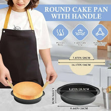 Black round cake pan with side handle, shown holding a finished sponge cake