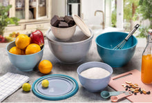 Plastic mixing bowls set in gray and teal with lids on a kitchen counter