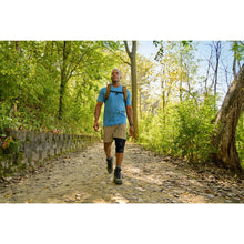 Black hinged knee brace worn on walking runner outdoors