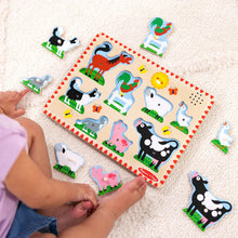 Kids playing with farm animal sound puzzle board and several pegs on the floor