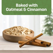 Oatmeal flakes in wooden bowl with cinnamon sticks