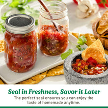 Glass Ball mason jars with metal lids, filled with chunky red preserve and herbs