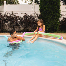 Foam pool noodles in pool: pink, green, and blue tubes