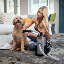 Pet grooming vacuum nozzle and hose in use on a dog