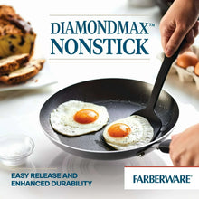Nonstick skillet with fried eggs and a cooking spatula.