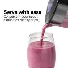 Blender pouring spout pouring pink smoothie into a glass cup