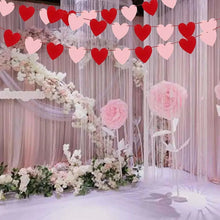 Red and pink felt heart garland banner draped along the wall