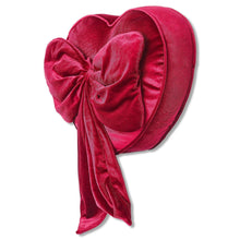Heart-shaped red decorative pillow with ruched bow, rounded back, and hanging tail ends.