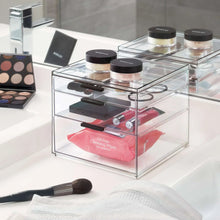 Clear acrylic cosmetic organizer drawers with makeup jars, brushes, and powder palettes