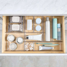 Clear 9-section drawer organizer for cosmetics, bottles, and grooming tools.