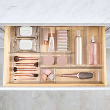 Clear 9-section drawer organizer with makeup tools, compact, and cosmetic bottles.