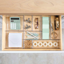 Clear 9-section drawer organizer with calculator, paper, and cotton swabs.