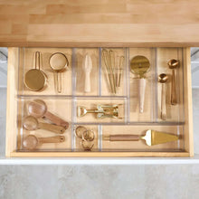 Clear 9-section drawer organizer with hair tools, brushes, and bottles.