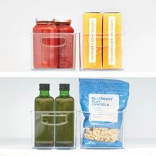 Clear plastic organizer bins with red jar, yellow boxes, green bottles, and granola