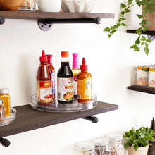 Clear turntable lazy Susan organizer holding bottles on a circular ridged tray