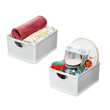 Set of 2 white stacking bins with oval cutout handles, one holding folded towels