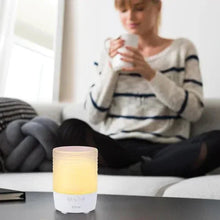 Small candle Bluetooth speaker with warm yellow glow and white front control panel