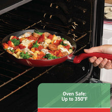 Red nonstick skillet in oven with sautéed vegetables