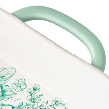 White platter lid with mint handle on rectangular ceramic baker, green floral detail