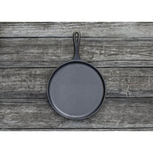 Seasoned cast iron griddle/comal, round pan with loop handle on wooden board