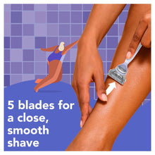 Woman shaving a leg with a blue-handled razor and cartridge, close-up