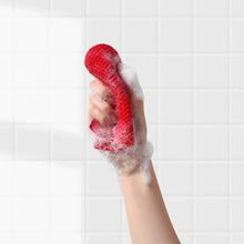 Red soft body cleaning glove with white soap foam on a hand