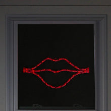 Lighted red lips LED window silhouette displayed in a window frame