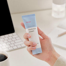 Panthetoin cream tube with blue cap, held in a hand