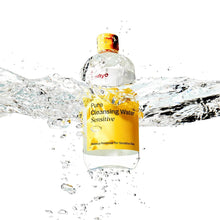 Cleansing water bottle with yellow cap and yellow label, surrounded by water splash