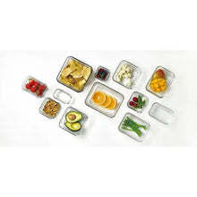 Glass food storage containers set with divided portions arranged on a white surface.