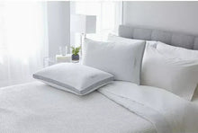 Pair of white bed pillows on a couch bed, standard rectangular shape