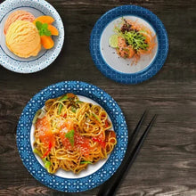 Paper bowls with blue snowflake rims containing pasta and soup, plus small side bowl