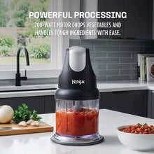 Ninja food chopper with clear bowl holding red chopped ingredients