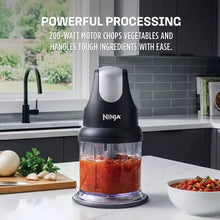 Ninja food chopper with clear cup filled with red chopped ingredients
