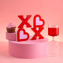 XOXO brick sign pieces in red and pale pink on a round display pedestal