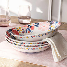 Stack of floral dinner bowls with patterned rim, white ceramic with blue red yellow flowers
