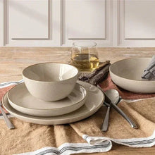 Ceramic 16-piece dinnerware set in beige, with bowls and plates arranged on table