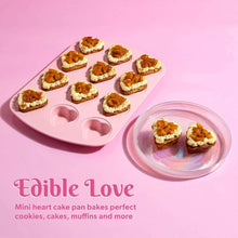 Pink mini heart baking pan with baked heart cookies and a bowl of hearts