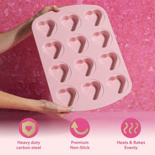 Pink mini heart cake pan with 12 heart-shaped molds, held in hands