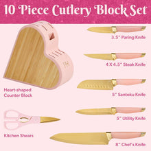 Heart-shaped counter block with pink-handled knives and wooden blade rests.